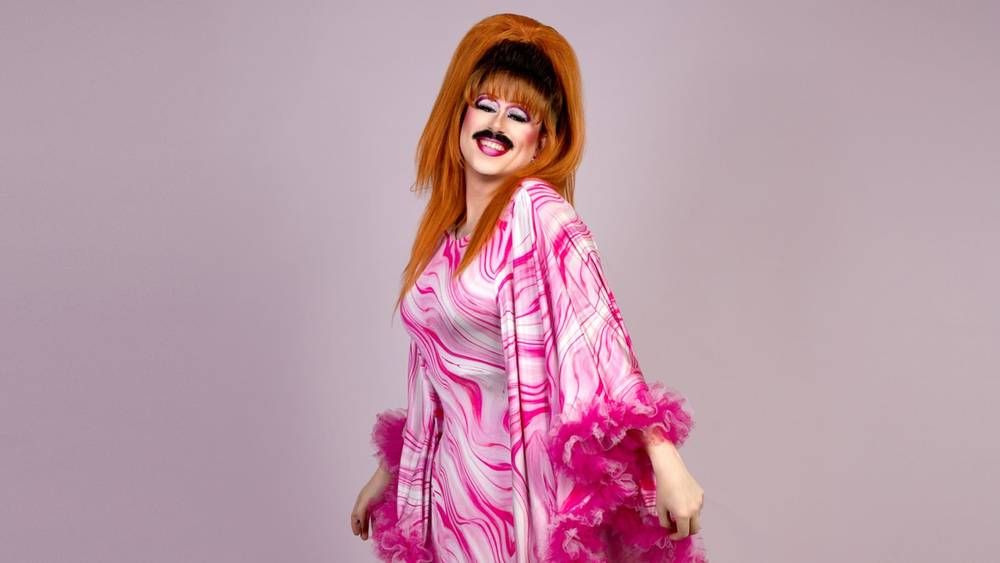 Flick in a pink marbled gown and ginger beehive, studio shot