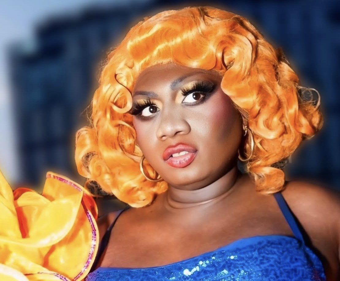 Yshee Black in an orange wig and blue sequins